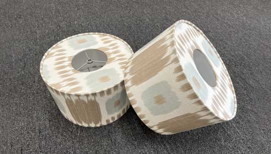 A pair of rolls of paper with brown and white designs.